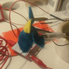 Then I wanted to do something interesting with fabric, so I used the metal chopstick as the core and created petals from fabric to use as the arrow buttons. It was a little tricky to do since the alligator clips were heavy and were pulling the fabric petals down.