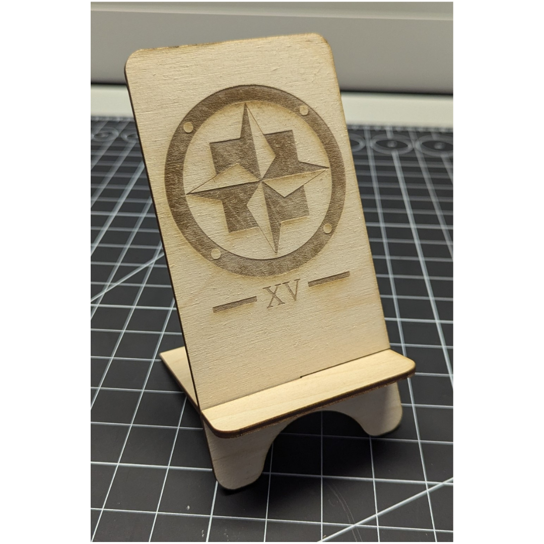 There is the laser-cut phone holder with a design on it. I found some details that could be improved, such as either cutting the rectangle deeper or adding a white line around the stand, but it still looks amazing.